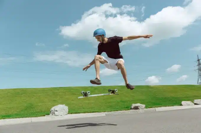 Jovem praticando manobras radicais com longboard em um dia ensolarado, simbolizando superação e autoconfiança.