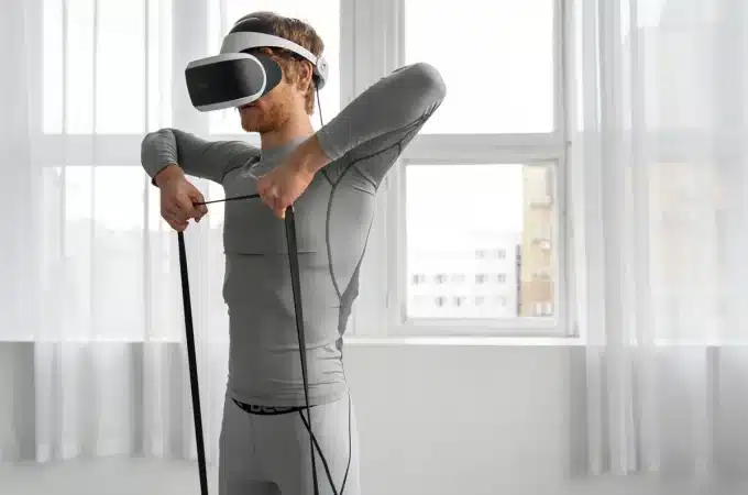 Homem utilizando óculos de realidade virtual enquanto realiza exercícios com faixa de resistência, simbolizando tecnologia e saúde.